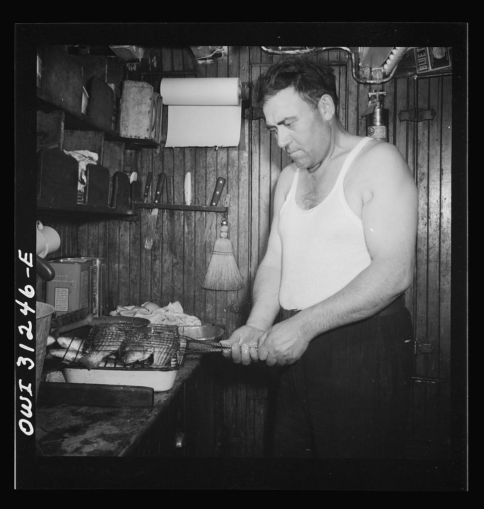 Ship's cook preparing to broil freshly-caught mackerel for supper