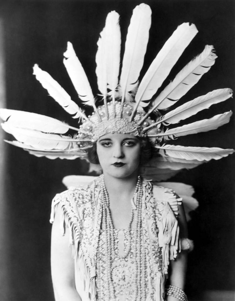 1923: Tallulah Bankhead wearing a large feather headdress and beaded necklaces - The Dancers