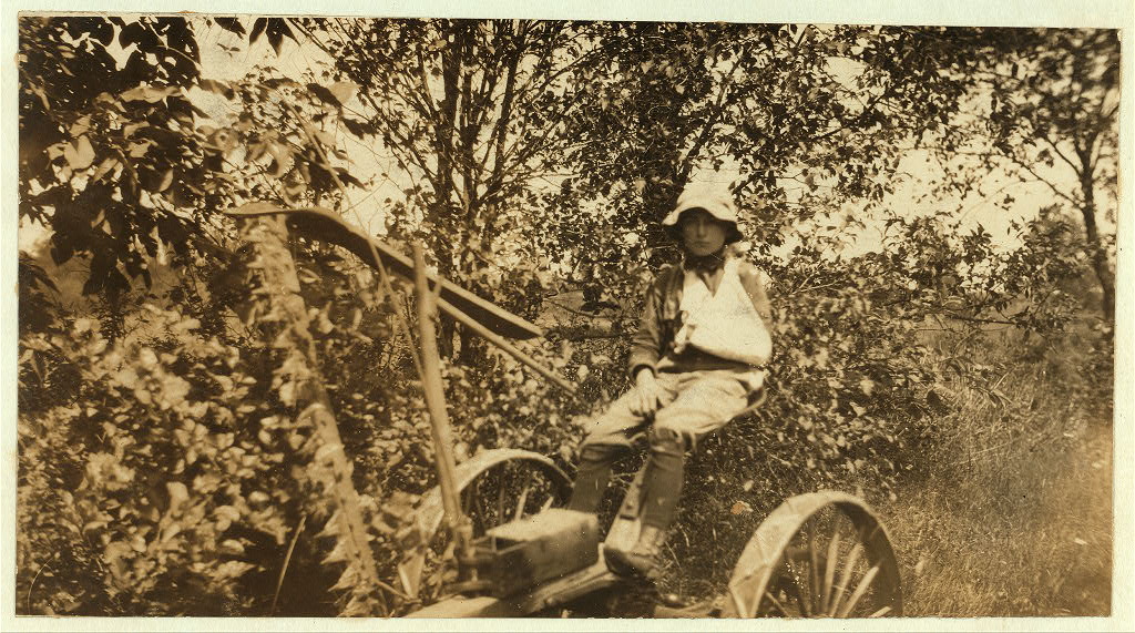Rural Accident. Twelve-year old Clinton Stewart and his mowing machine which cut off his hand. See Hine Report, August 1915.