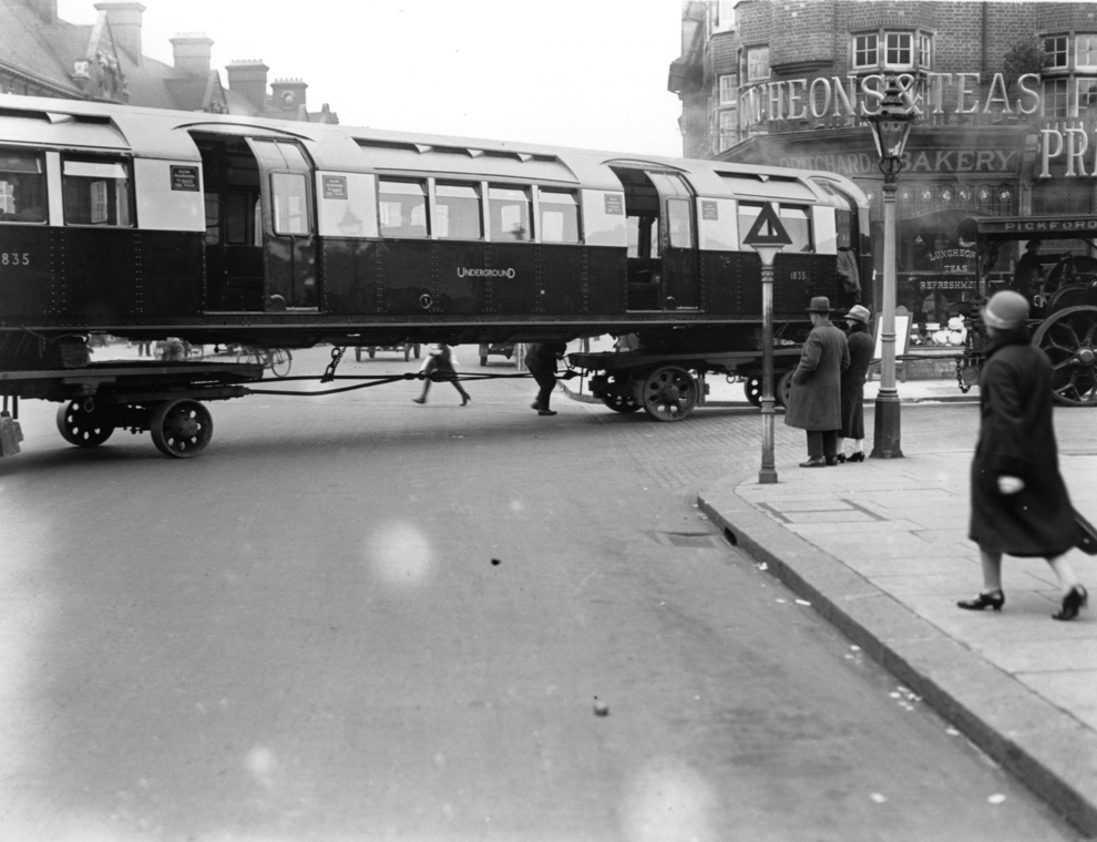 An underground train being transported on wheels through the streets of London, 1926.