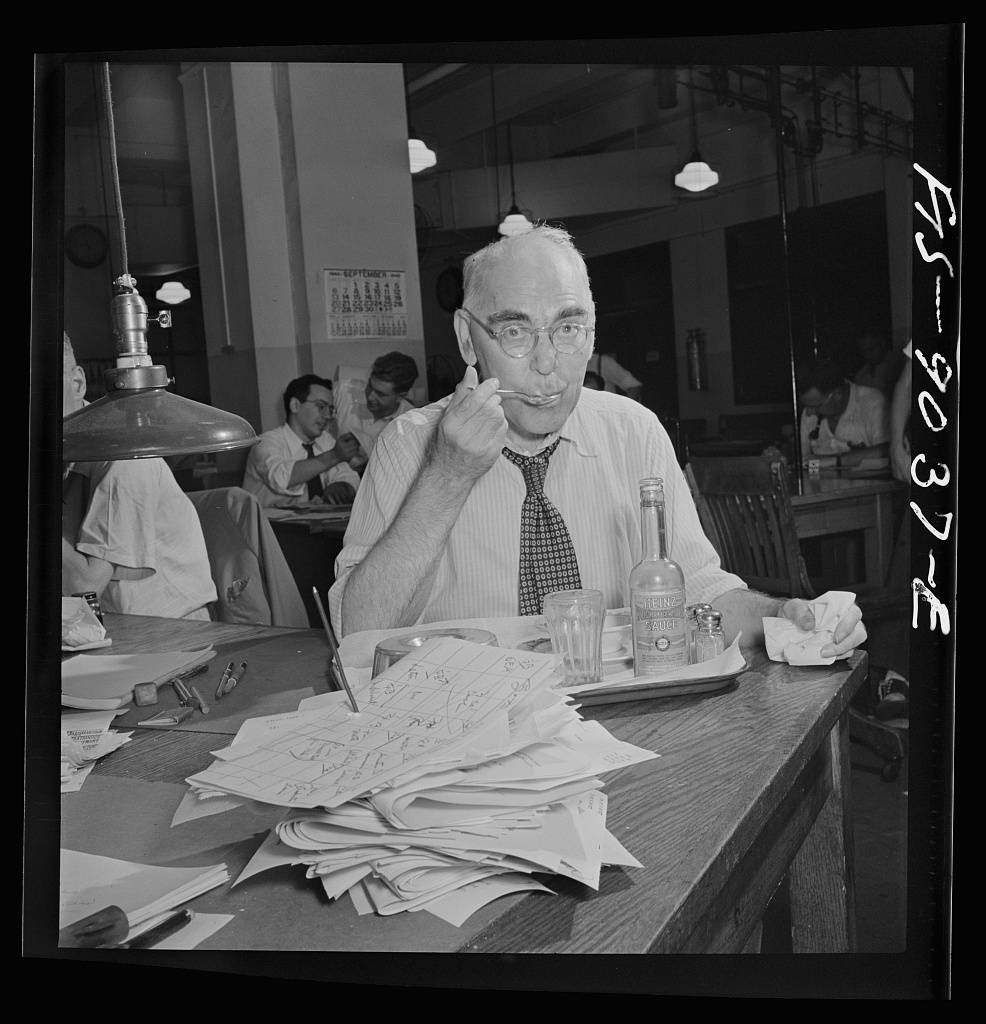 Financial desk copy reader on the New York Times newspaper staff has lunch on tray ordered from outside. Lunch in the news room is a half-hour period about 11 PM between editions