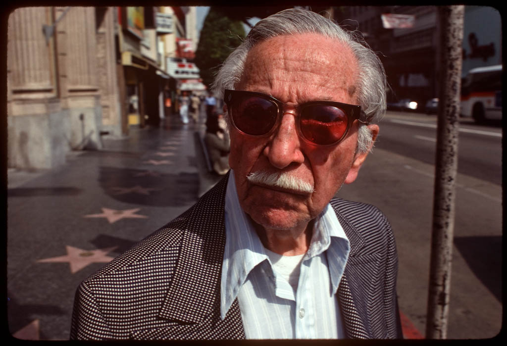 Rosecolored glasses guy on Hollywood Boulevard at a bus stop