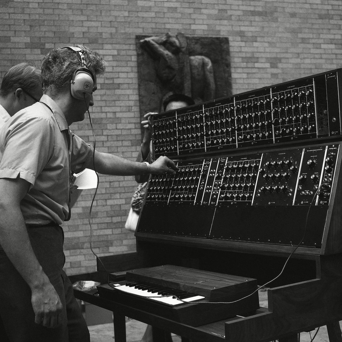 obert Moog, 35, who designed the best known of the electronic musical synthesizers, makes final adjustment on the Moog Synthesizer prior to a jazz concert at Museum of Modern Art, New York. Two quartets played four Moogs during the hour and a half long concert in the Museums open air sculpture garden. Some 4,000 persons attended the concert Robert Moog 1969, New York, USA