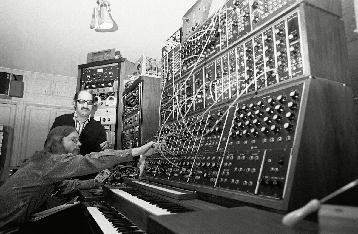 his array of keyboards, patch cords, knobs, dials, flashing lights and tape recorders is called a Moog synthesizer, a device which Mort Garson, rear, says an simulate any sound, musical or nonmusical. Operating the equipment is Gene Hamblin, . There are several hundred similar devices, made by Robert Moog of Trumansburg, N.Y., around the country, mostly in colleges teaching electronic music 27 Jan 1971
