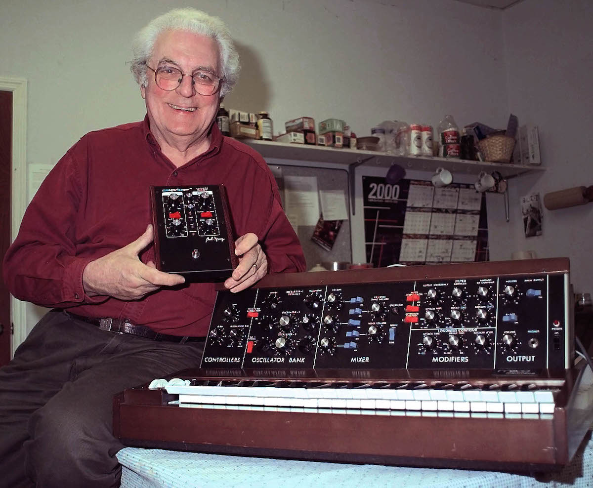 MOOG Synthesizer pioneer, Robert "Bob" Moog, holds a new Moogfooger synthesizer as he sits next to a 1971-era Minimoog synthesizer in his Asheville, N.C.. office, . Moog has been making and playing synthesizers for more than three decades MOOG MUSIC, ASHEVILLE, USA