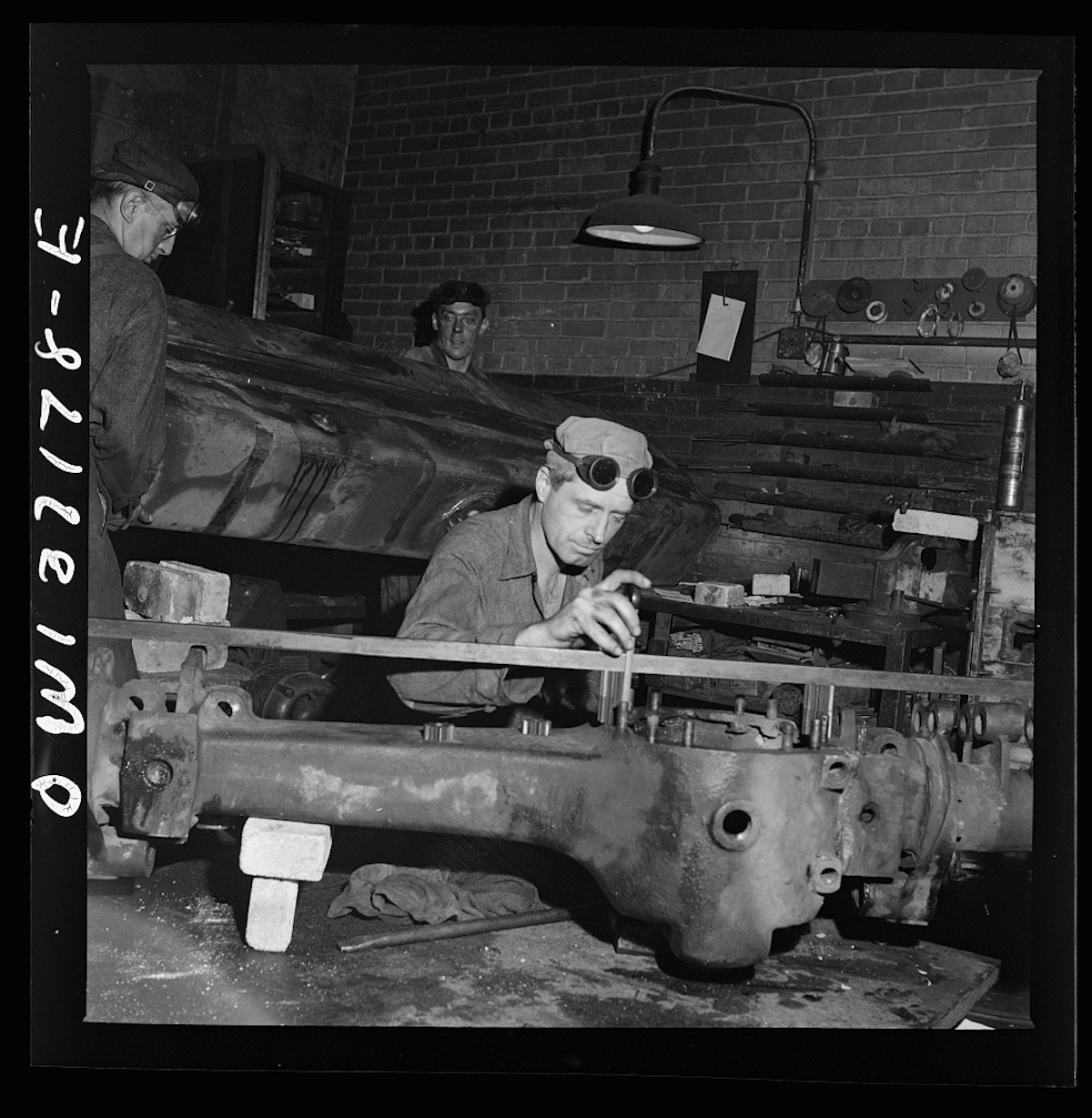 Pittsburgh, Pennsylvania. A mechanic working on a rear axle housing at the Greyhound garage