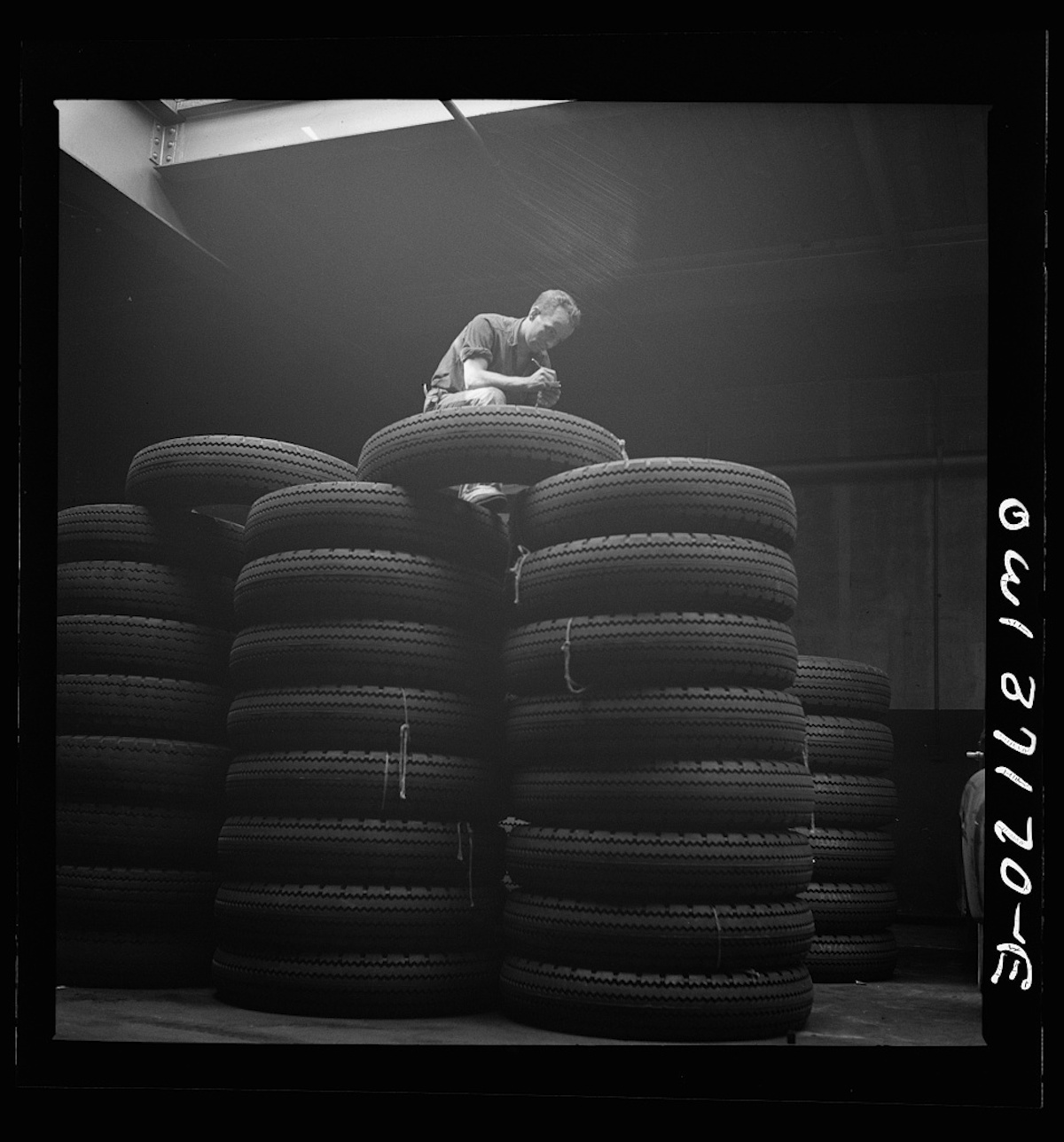 Pittsburgh, Pennsylvania. Checking brand numbers on new tires at the Greyhound garage