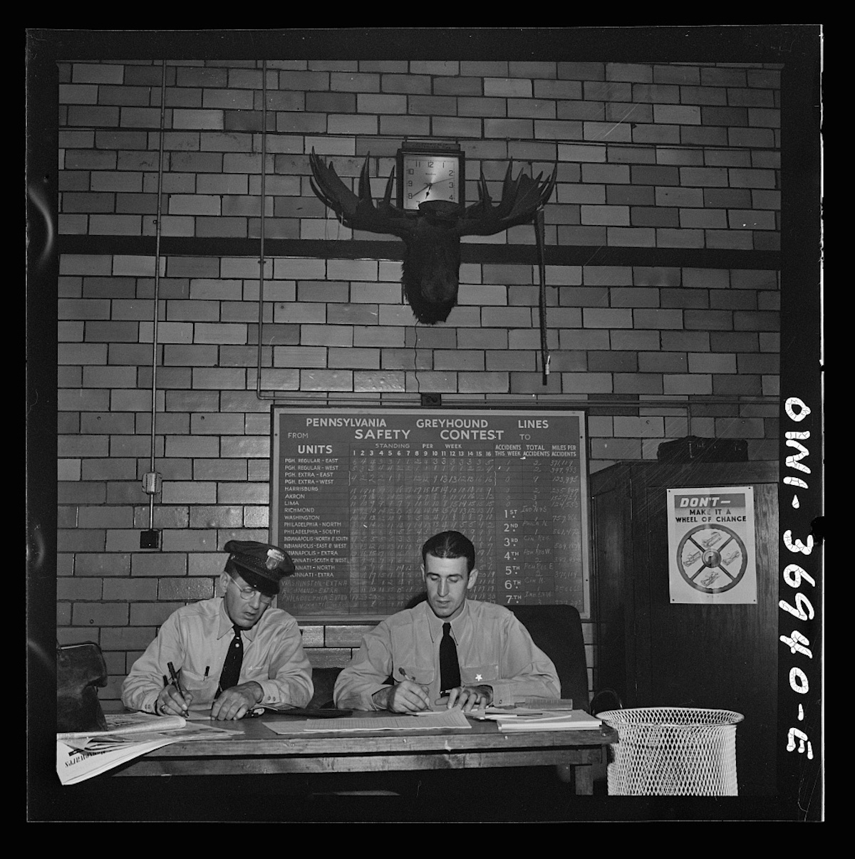 Pittsburgh, Pennsylvania. Greyhound bus drivers writing out trip reports in the garage