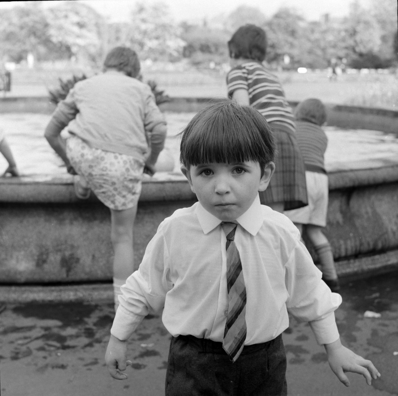 Ireland 1960s. Any of you familiar with St. Stephen's Green in Dublin will recognise the fountain behind this little chap. It's the one where the water emerges from bulrushes. Photographer: Elinor Wiltshire Date: 1964