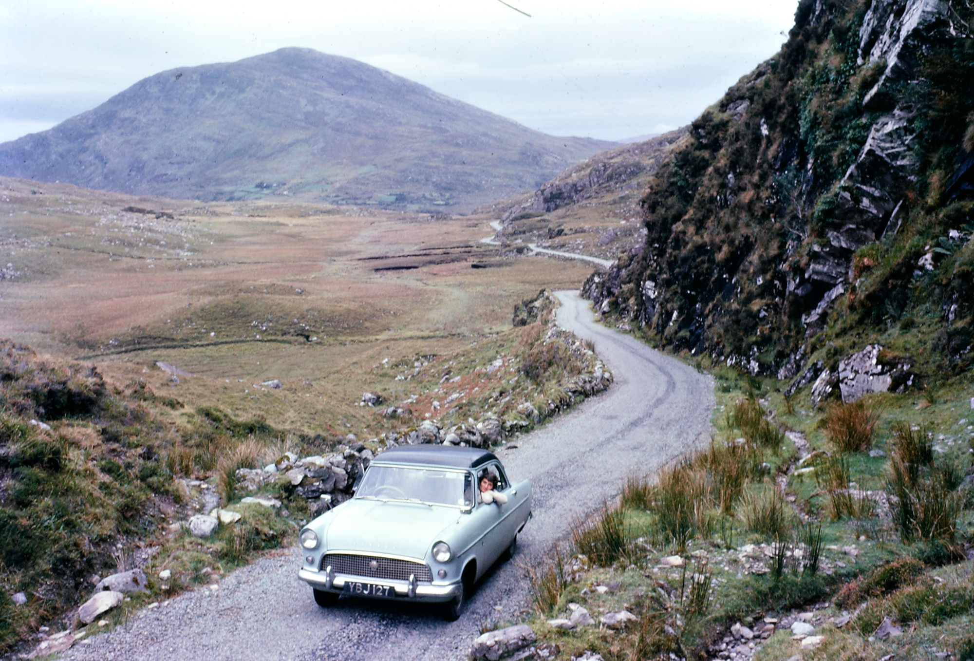 Ireland 1960s, Ring of Kerry Big challenge for you today! Though of course, every time I say that, someone solves the puzzle in 5 minutes. Anyway, we'd love to identify this exact spot… photogaff is first off the mark, suggesting: "That looks like a hundred metres or so on the Sneem side of the first lake heading towards Killarney at the brow of the Killarney lakes area" and franmol thinks this is right too. Meanwhile, DannyM8 and Niall McAuley think the woman leaning out the window is writer and naturalist Rosemary Elizabeth Tilbrook (aged about 32), wife of the photographer Richard Tilbrook. Niall also found what may be a photo of Rosemary Tilbrook taken in 1998 (white haired and smiling, a year before she died), and this lovely story about her: "The toads in Ashwellthorpe live in Ashwellthorpe Wood on the north side of Aswellthorpe Street, but their breeding pond lies to the south of the road – toads can live for up to forty years and always return to their same breeding pond, year after year. Some of you will remember that Rosemary Tilbrook who lived in Red Squirrels used to ferry toads/frogs/newts across the road for many years up until her death in 1999. There are now some 15 volunteers including youngsters with their parents in Ashwellthorpe who will come out in all weathers to help this migration." And the car has also been identified as a Ford Consul Mk II, registered in East Suffolk, England in 1958. Date: Circa 1960