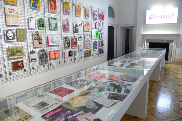 PRINT! is staged in Somerset House’s Terrace Rooms; the exhibition’s graphic identity was created by Scott King. His distinctive fluoro pink logo is on the lightbox at the far end of room 1. Photo: Doug Peters