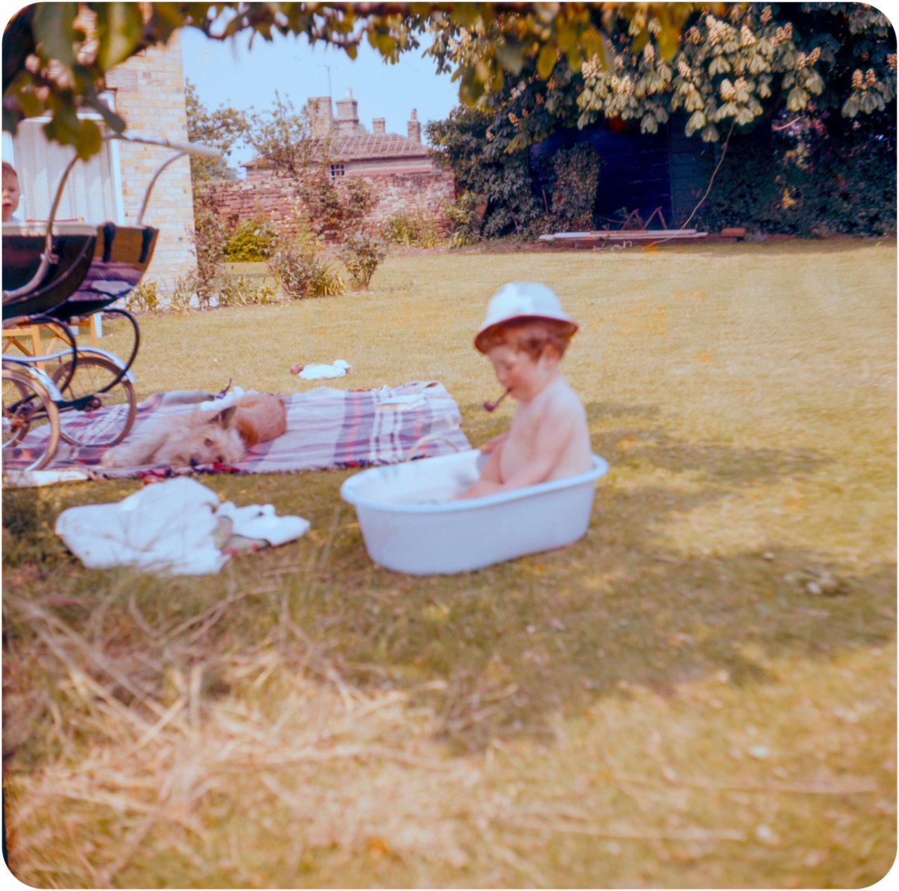 Baby in bath, smoking a pipe - Cornwall Circa 1960