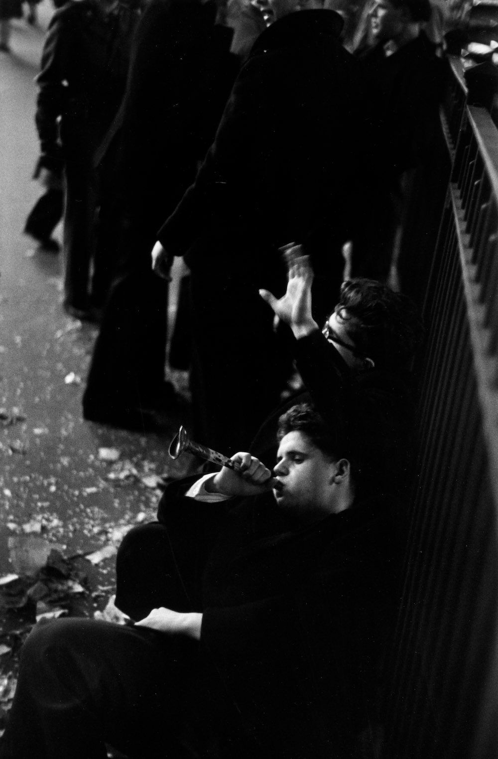 Jan. 1, 1952 A young man slumped against railings blows on a battered toy trumpet during New Year's celebrations in Times Square, New York.