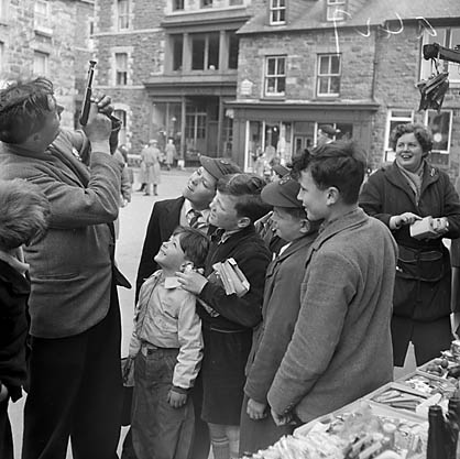 Dolgellau Fair Teitl Cymraeg/Welsh title: Ffair Dolgellau Ffotograffydd/Photographer: Geoff Charles (1909-2002) Nodyn/Note: Robert Keith Jones with a toy gun Dyddiad/Date: April 26, 1956