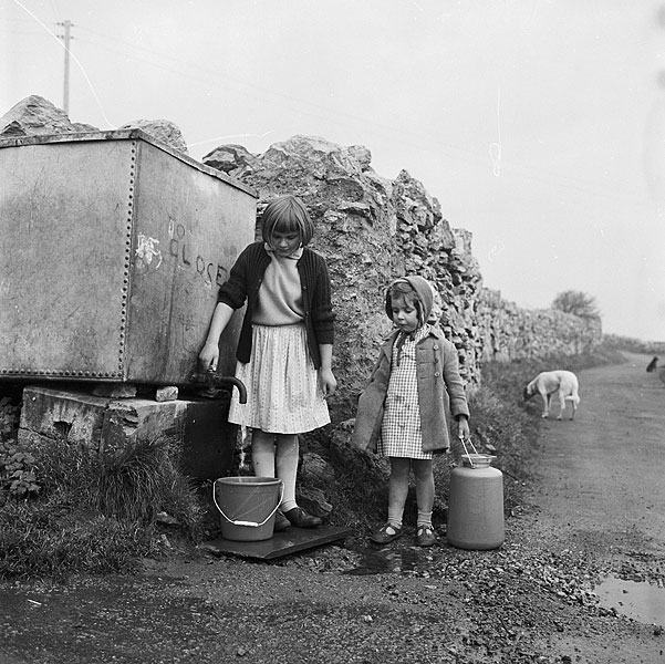 Girls carrying water, Anglesey Teitl Cymraeg/Welsh title: Merched yn cario dwr yn Sir Fon Ffotograffydd/Photographer: Geoff Charles (1909-2002) Dyddiad/Date: December 1, 1962.