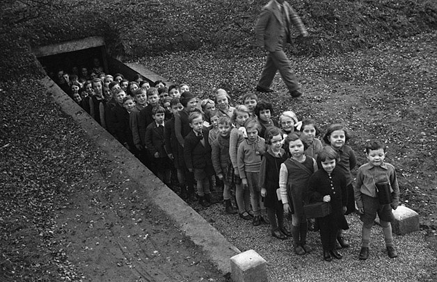 Children outside air raid shelter, Gresford Teitl Cymraeg/Welsh title: Plant tu allan i gysgodfa rhag cyrchoedd awyr, Gresfordd Ffotograffydd/Photographer: Geoff Charles (1909-2002) Dyddiad/Date: November 10, 1939.