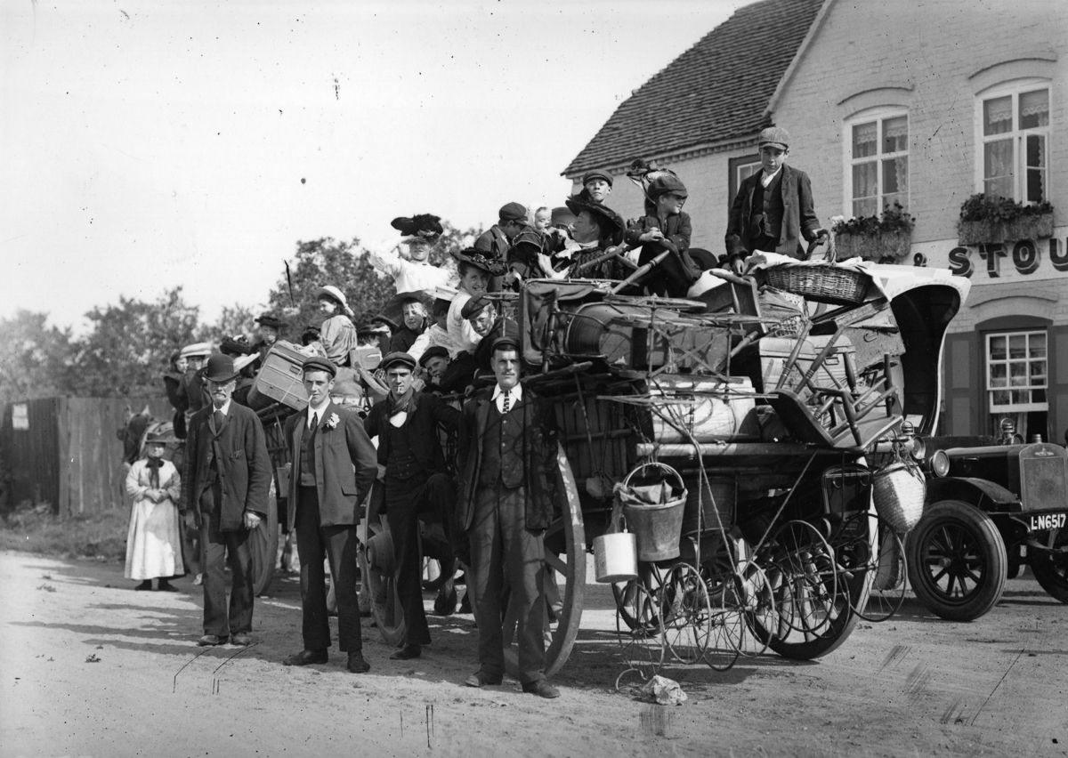 1907 A family of hop pickers stand beside their packed cart.
