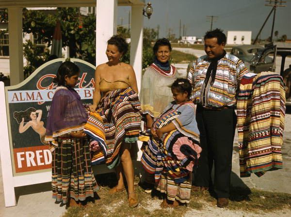 Seminole family selling patchwork clothing near the Brighton Reservation Local call number: JJS0297 Title: Seminole family selling patchwork clothing near the Brighton Reservation Date: January 27, 1948