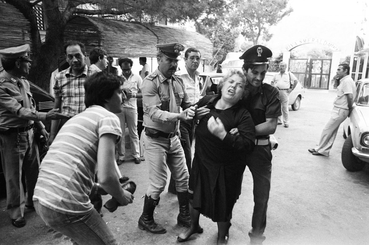 Woman shouts as police hold her back mafia Sicily Italy 