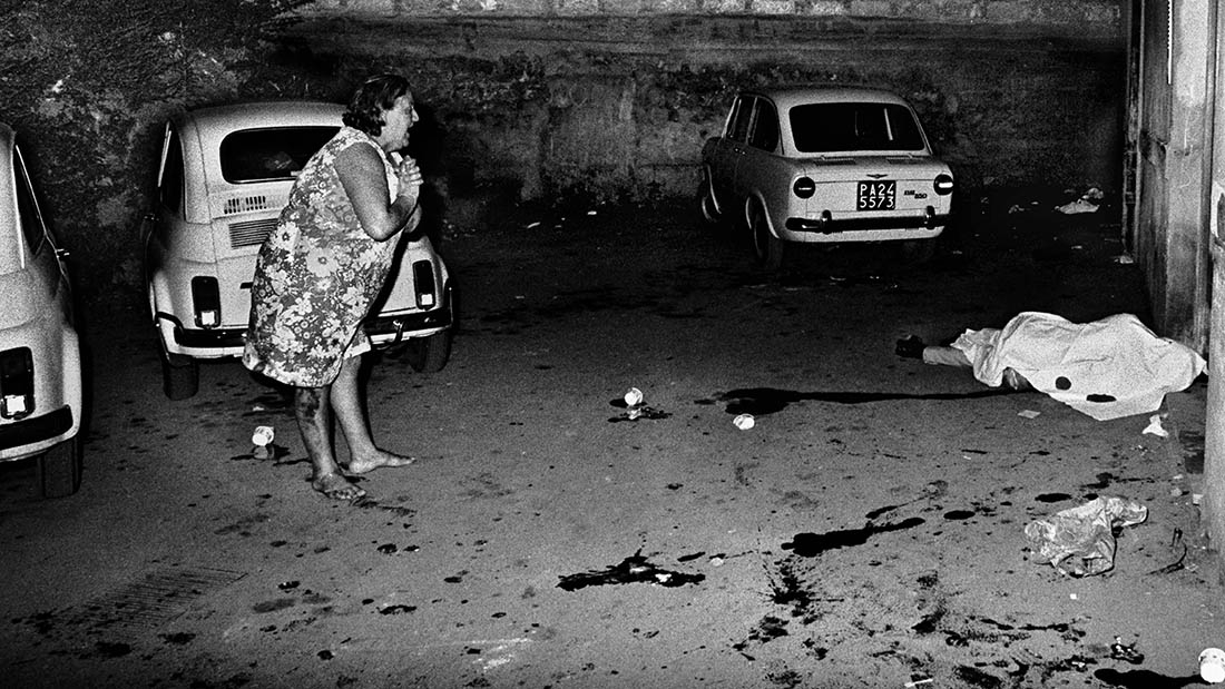 A woman screams near a dead body in a car park mafia Sicily Italy 