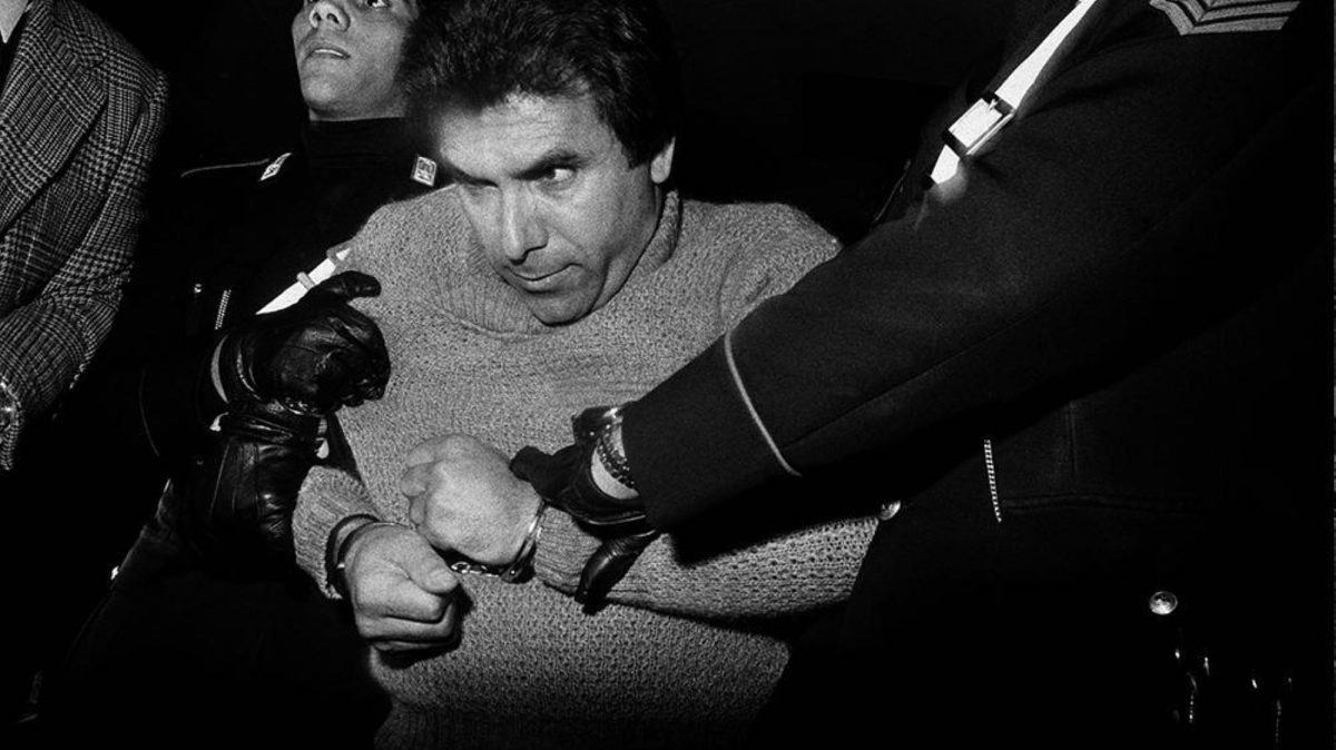 A man in handcuffs struggles as police hold him mafia Sicily Italy 