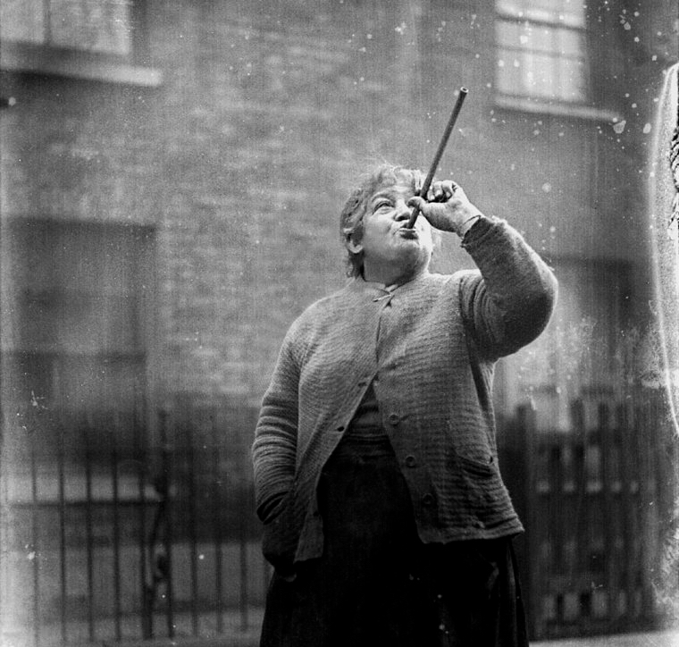 Woman points pea shooter at a window