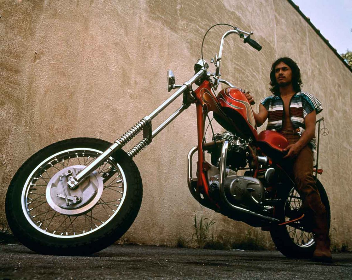 Red chopper with rider posed on the seat