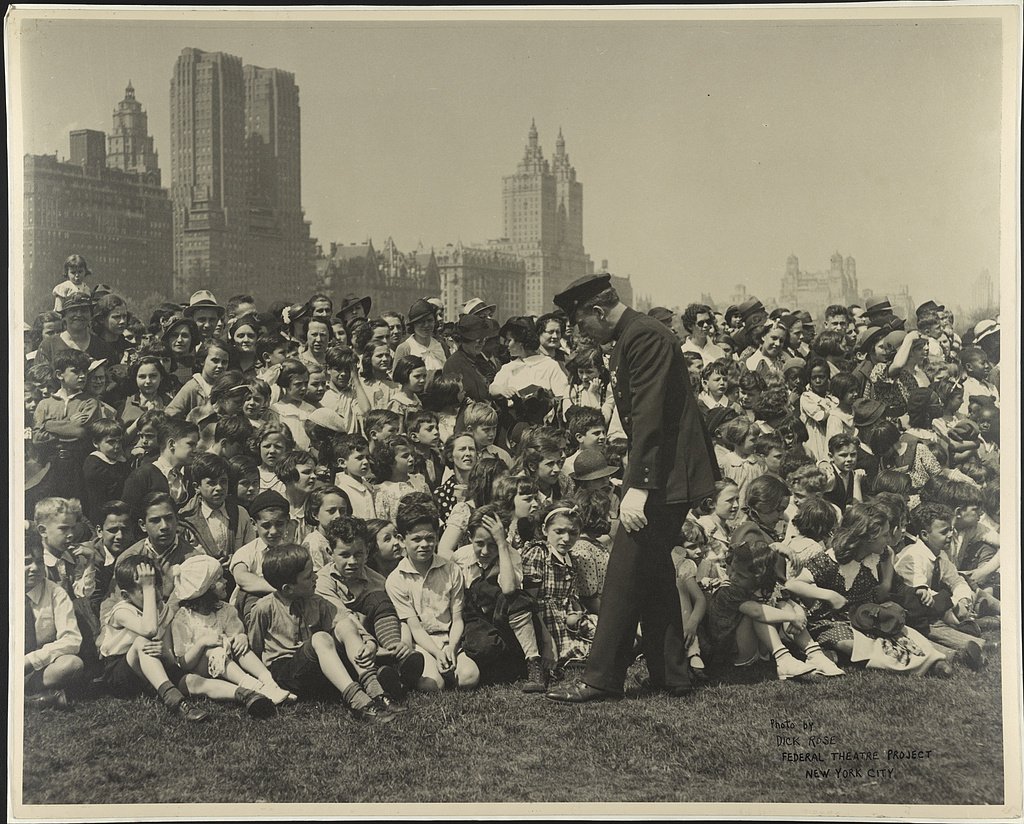 Title: [Police officer in front of crowd of children and adults at Federal Theatre Project performance in Central Park, New York] / photo by Dick Rose, Federal Theatre Project, New York City. Creator(s): Rose, Dick, photographer Date Created/Published: [between 1935 and 1939]