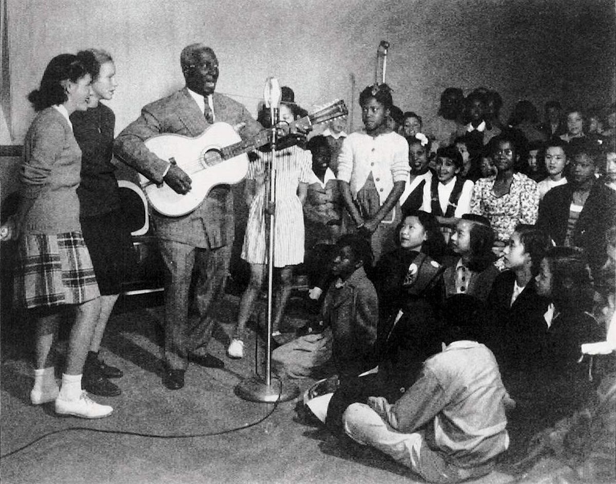 Lead Belly performs for a group of children