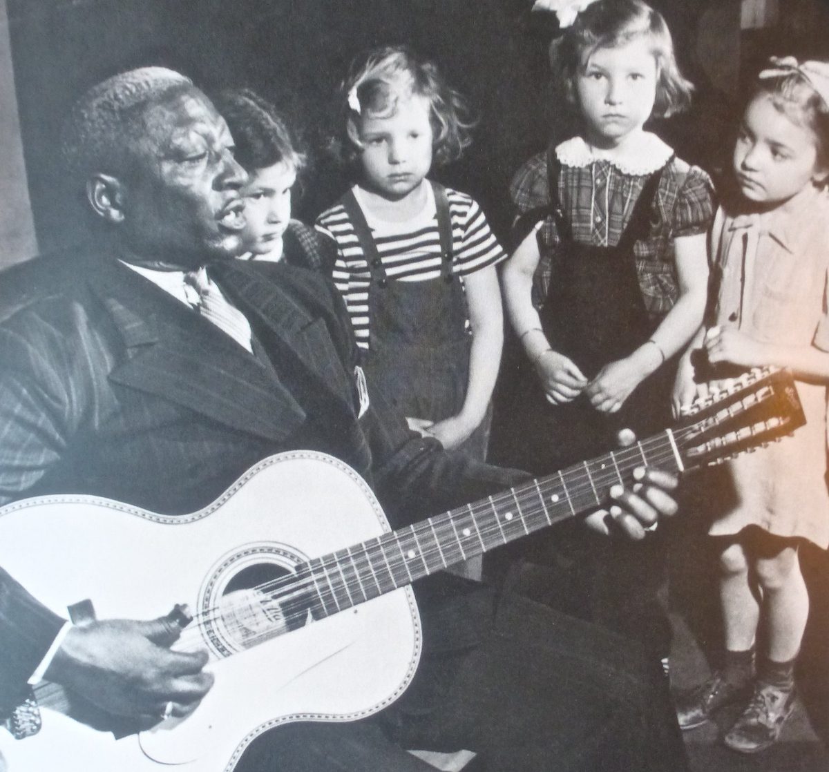 Lead Belly plays for a group of children