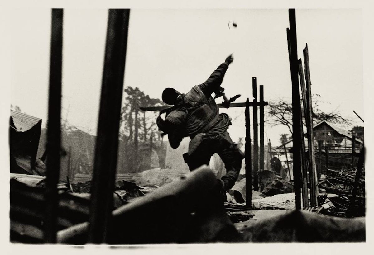 Don McCullin, "US soldier as he throws a grenade at North Vietnamese soldiers, moments before he was shot by a sniper," Hue, Vietnam, 1968