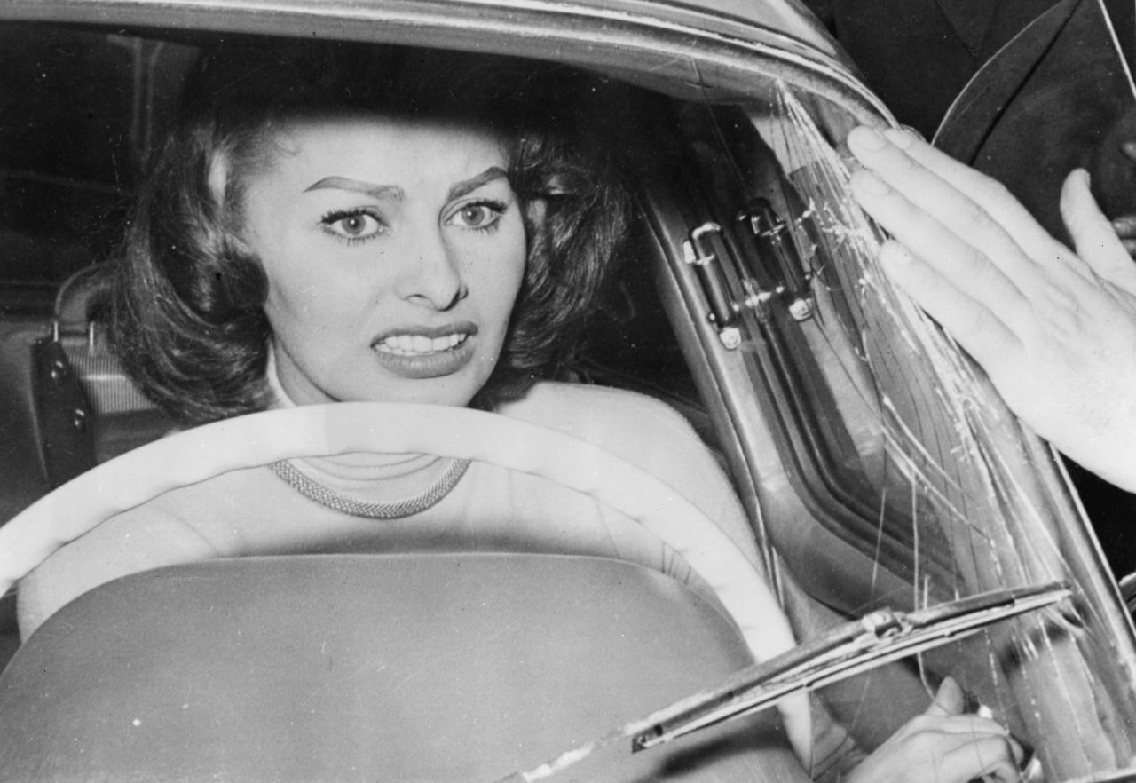 Sofia Loren cowers in her car as a crowd of ardent fans press around her  during the annual Rome to San Remo Cinema Car Rally on April 9, 1956 -  Flashbak