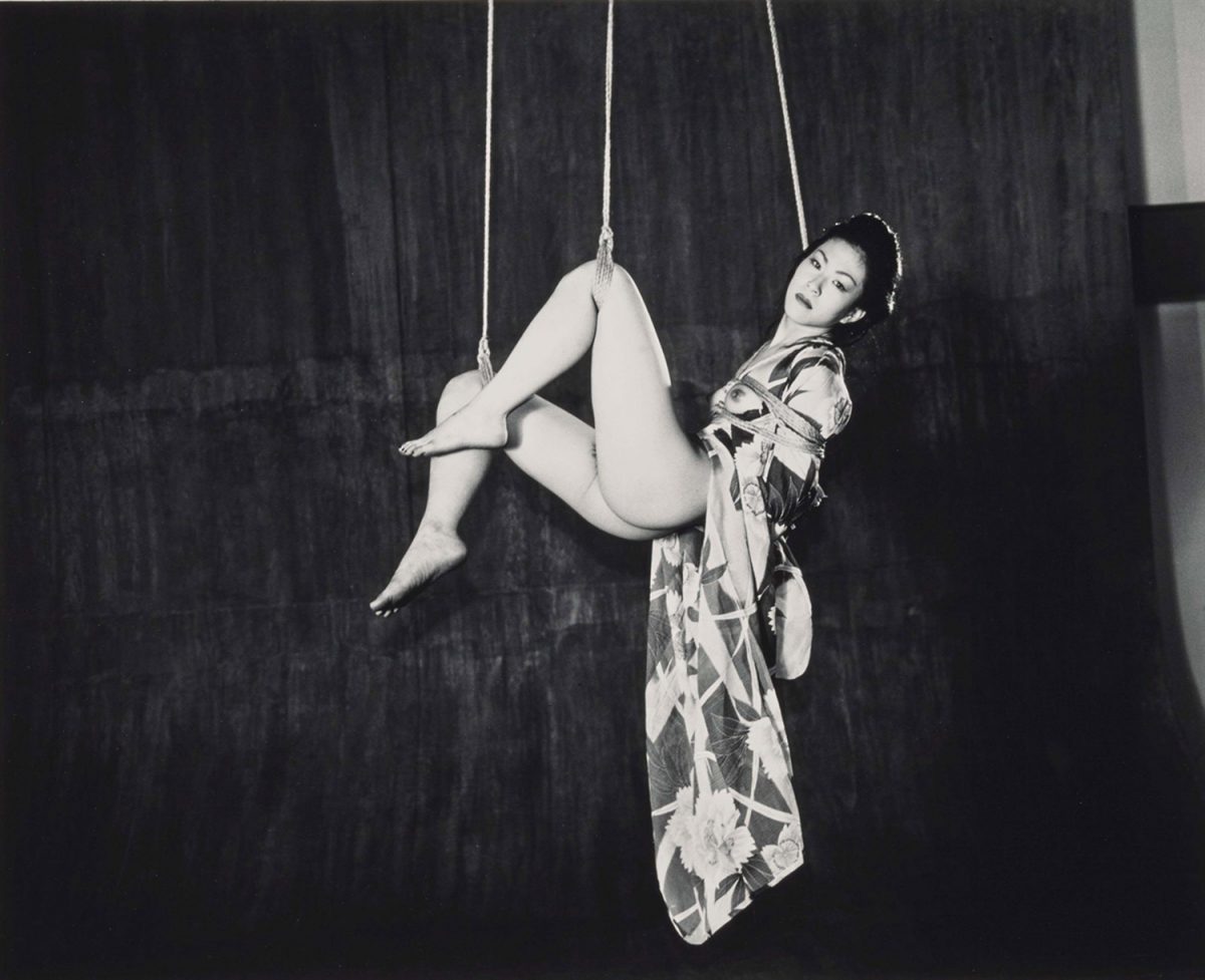 Nude woman hanging in shibari tied ropes Stock Photo