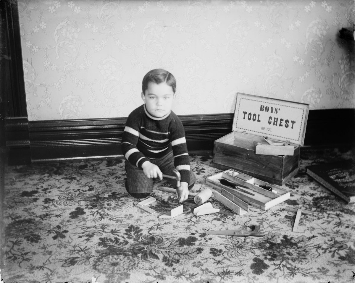 Boy playing with Boy's Tool ChestGeorge Silas Duntley Photographs 1899-1918