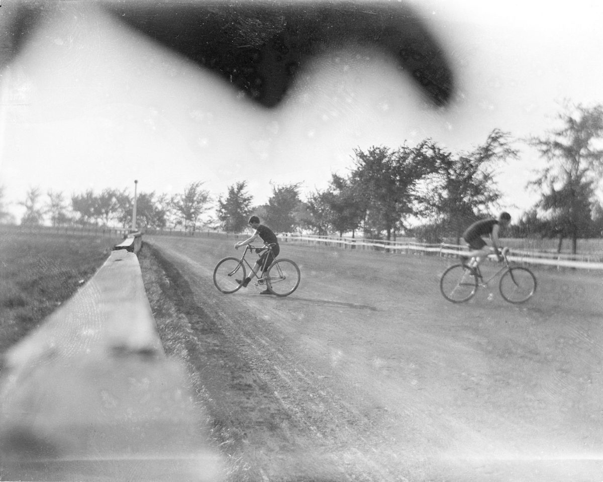 Two unidentified boys riding bicycles on race trackGeorge Silas Duntley Photographs 1899-1918