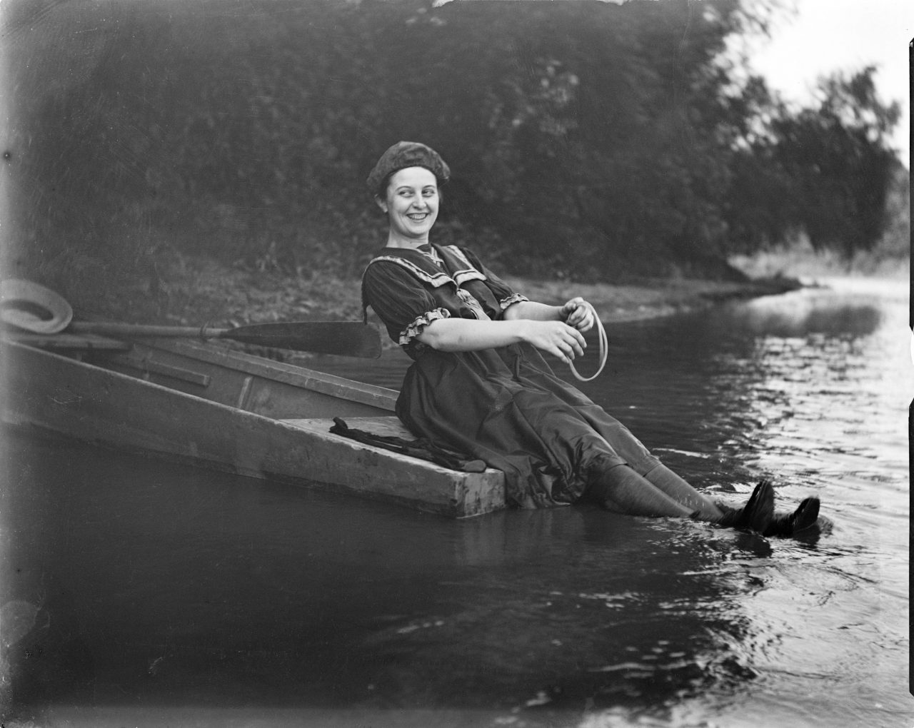 Unidentified woman sitting on the back of row boat with feet in waterGeorge Silas Duntley Photographs 1899-1918