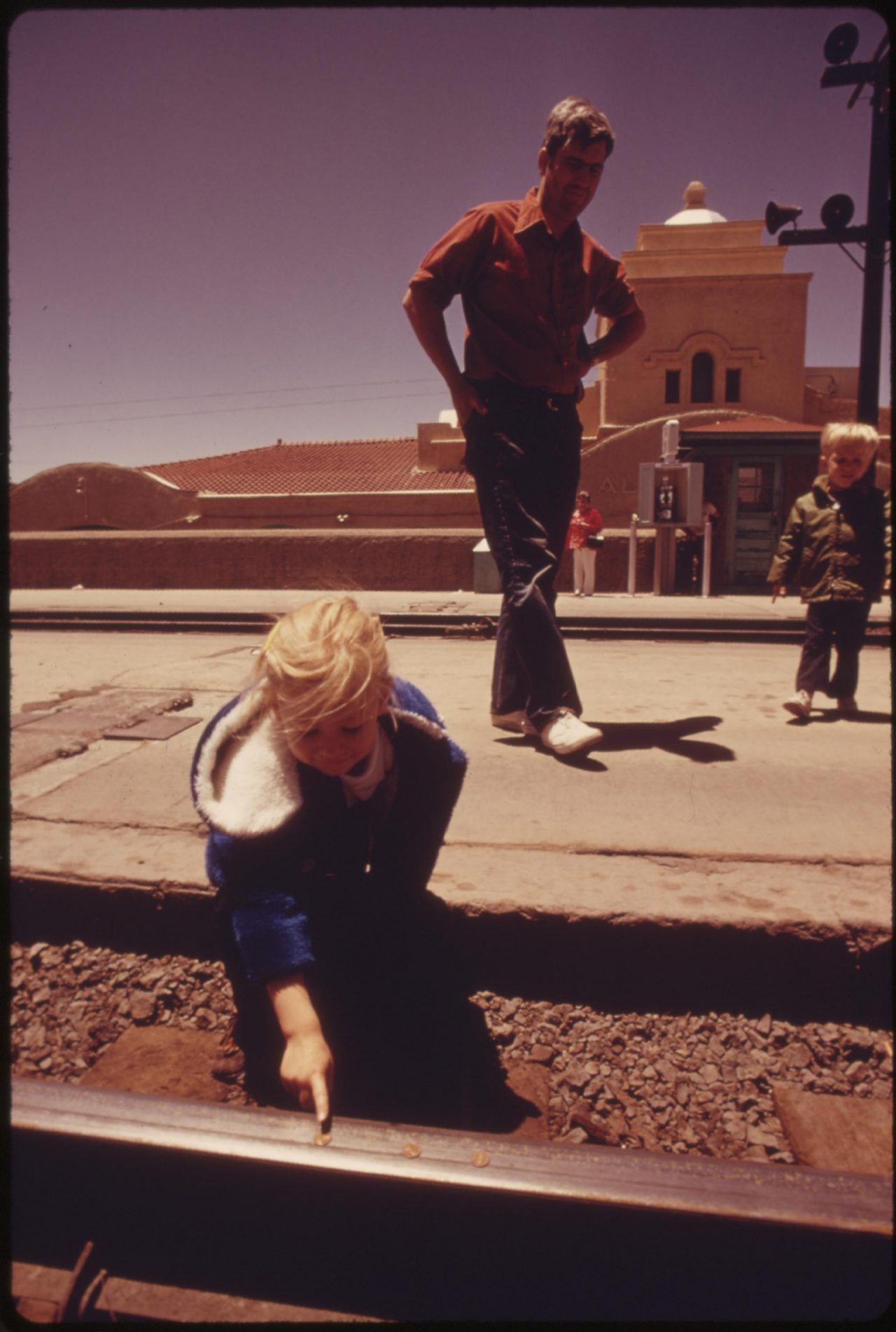 A child places pennies on the track at the Albuquerque, New Mexico, train station and will wait for the Southwest Limited to flatten them as a souvenir, June 1974