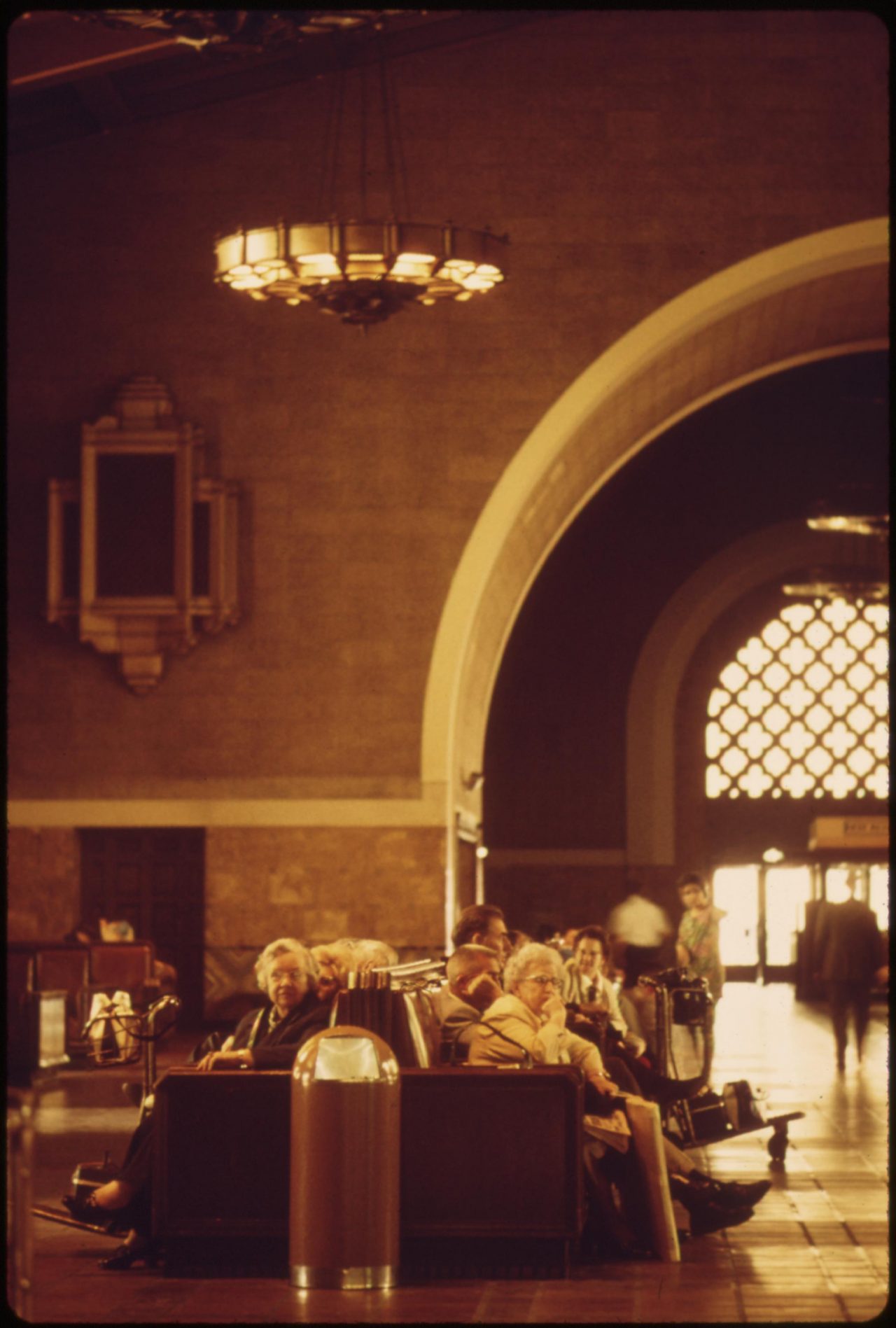 Amtrak passengers waiting for passenger trains in the interior of the Los Angeles Union Passenger Terminal, which was built for the 1932 Summer Olympics in that California city, May 1974