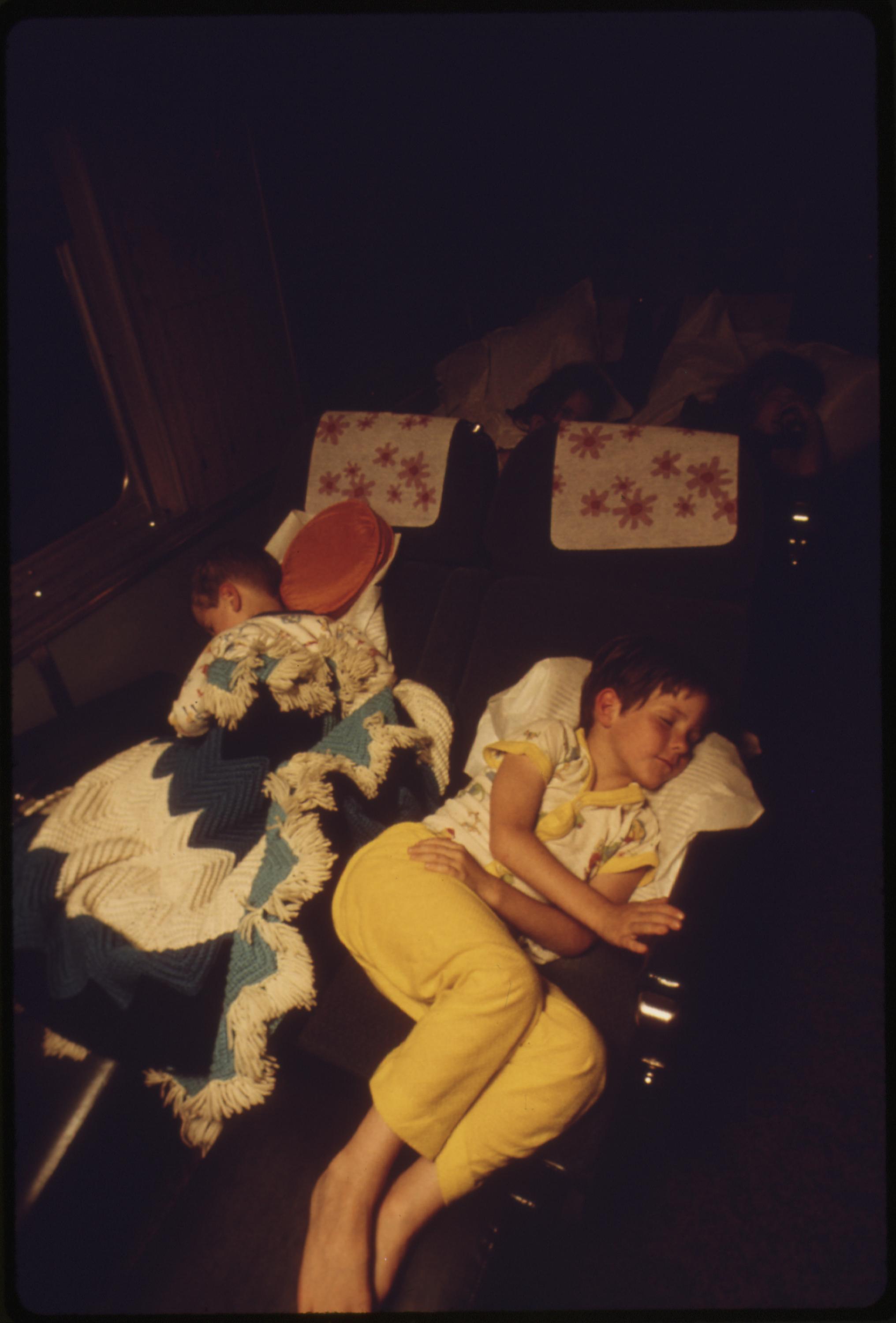 Children sleeping in one of the chair cars on the Southwest Limited, an overnight train from Los Angeles, California, to Albuquerque, New Mexico, June 1974