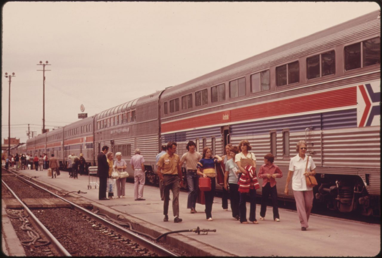 Passengers of the Southwest Limited strolling beside the Amtrak train at Albuquerque, New Mexico, as it halts for refueling enroute to Chicago from Los Angeles, California, June 1974