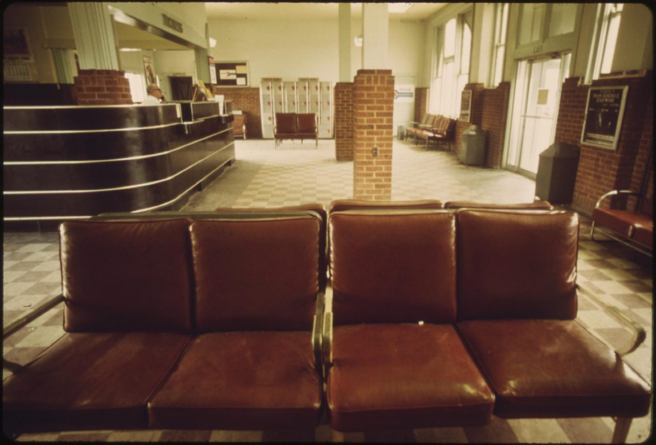 Ticket agent at the Amtrak station in Dodge City, Kansas mans his desk awaiting customers, June 1974