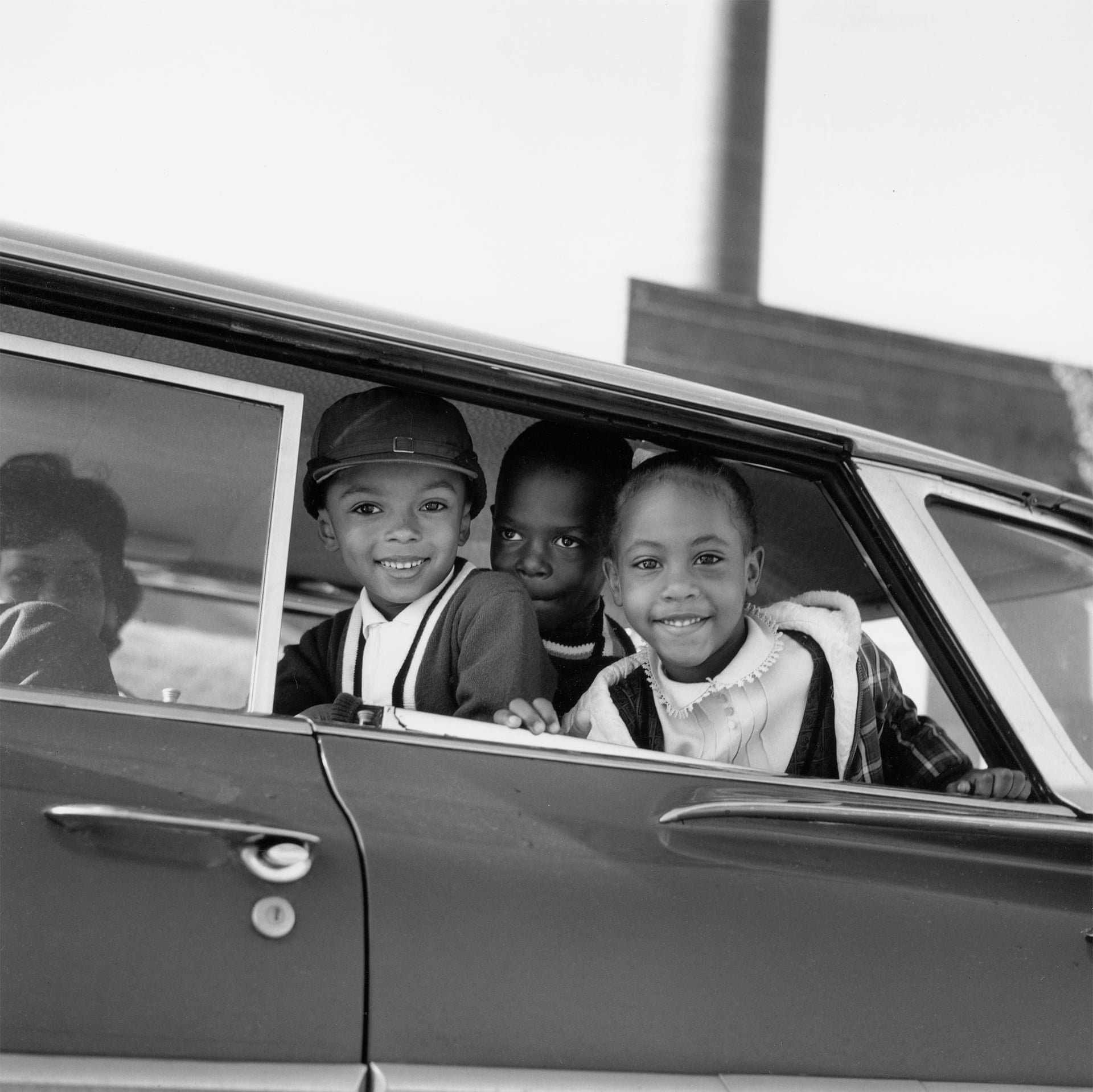 Michael Willis, Harry Williams and Dwania Kyles sit in the back of a car during the first day of Memphis school integration, 1961