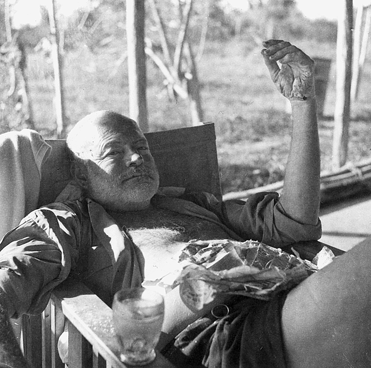 Description: Ernest Hemingway at a fishing camp in Shimoni, Kenya. He is showing a blistered hand and other injuries he sustained from two successive plane crashes and a recent bushfire. Credit Line: Ernest Hemingway Collection. John F. Kennedy Presidential Library and Museum, Boston. Date: 1954
