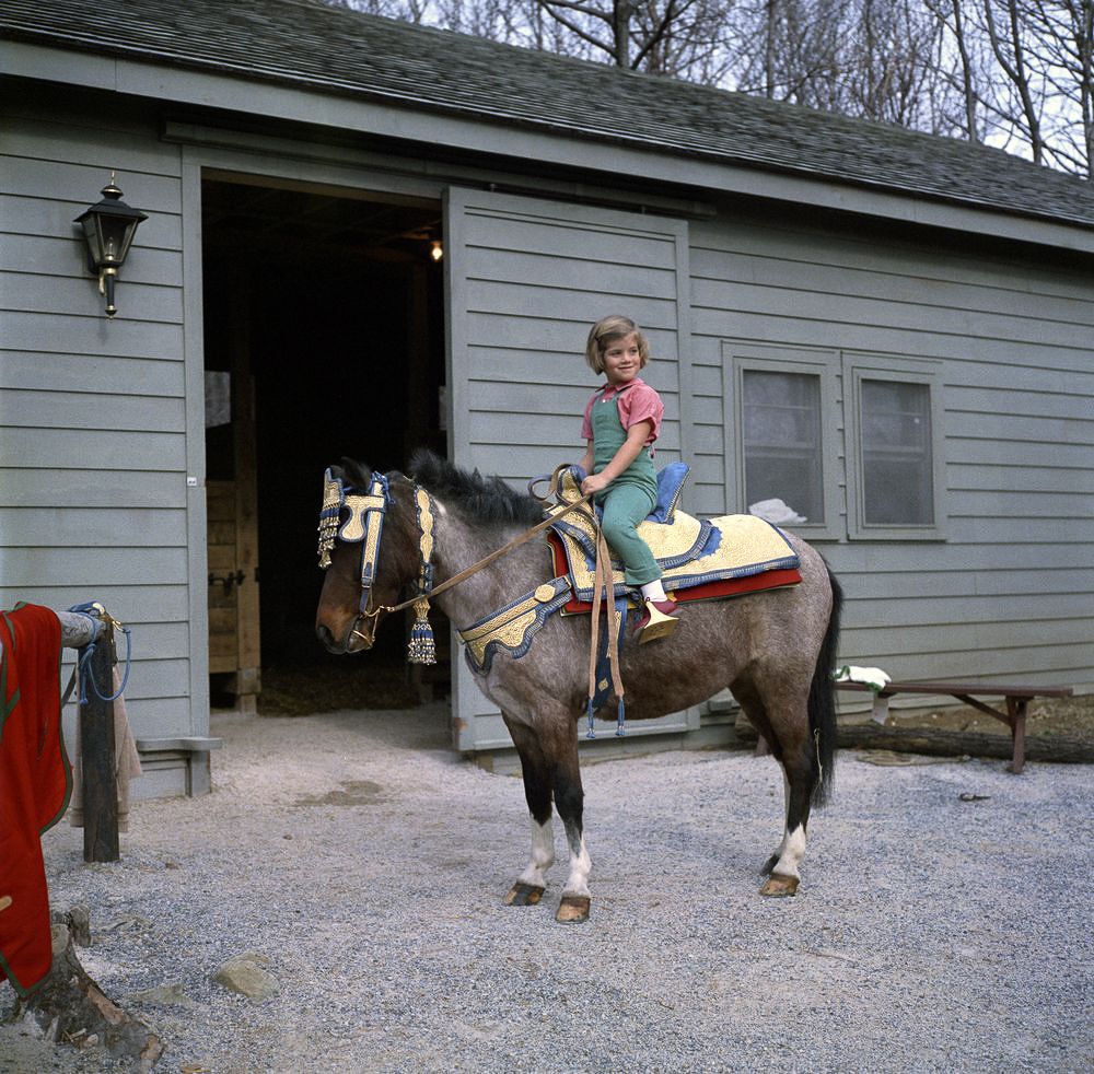 March 31, 1962 During a weekend at Camp David, Caroline and Macaroni test out a new saddle given to the family by King Hassan II of Morocco.