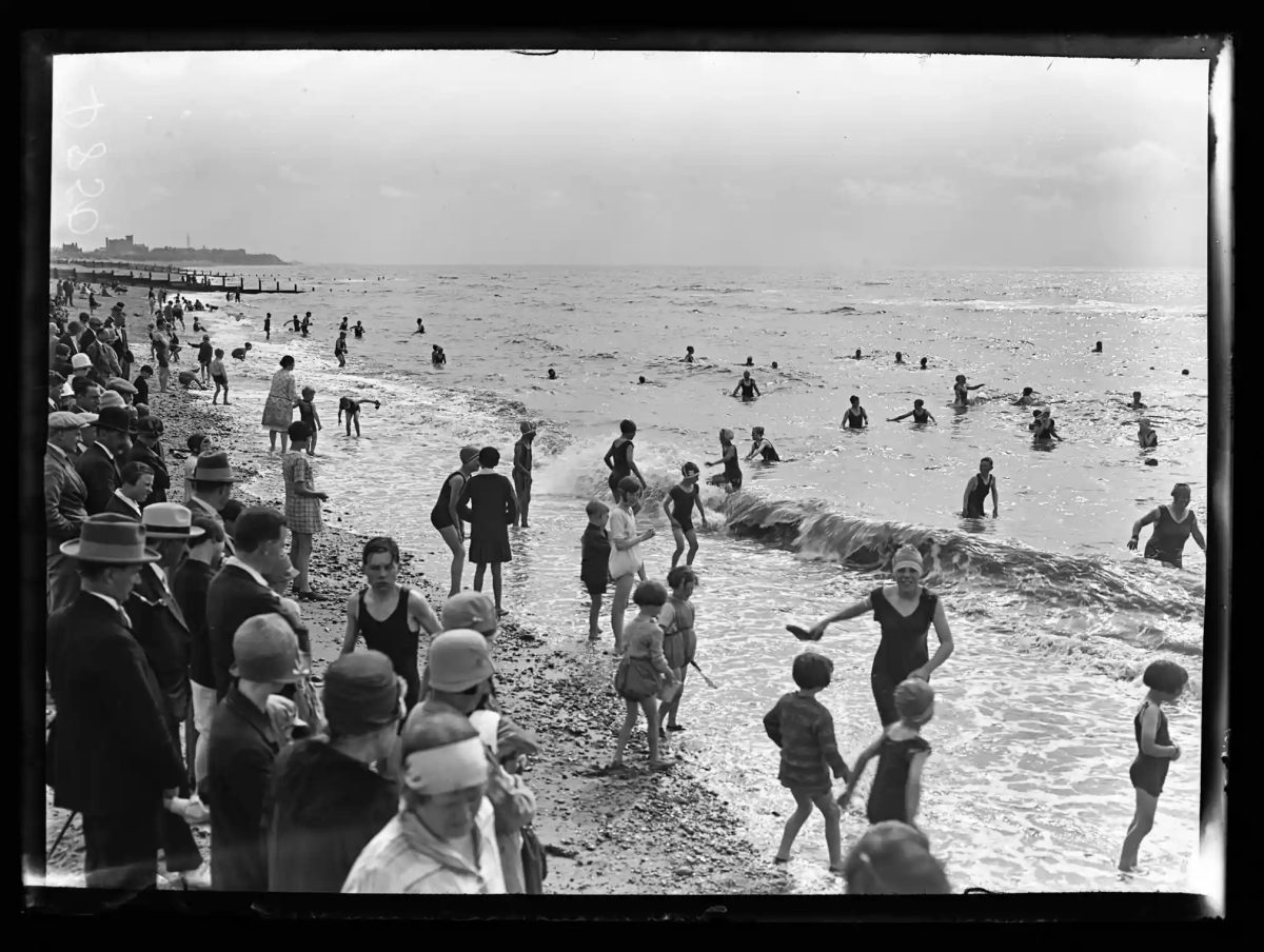 Bathers on Cleveleys beach, with Blackpool and its tower in the background