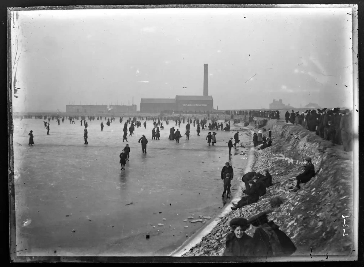 Skating on Ormsgill reservoir, Barrow-in-Furness. P Hodgson & Co’s soap and candle works is visible in the background