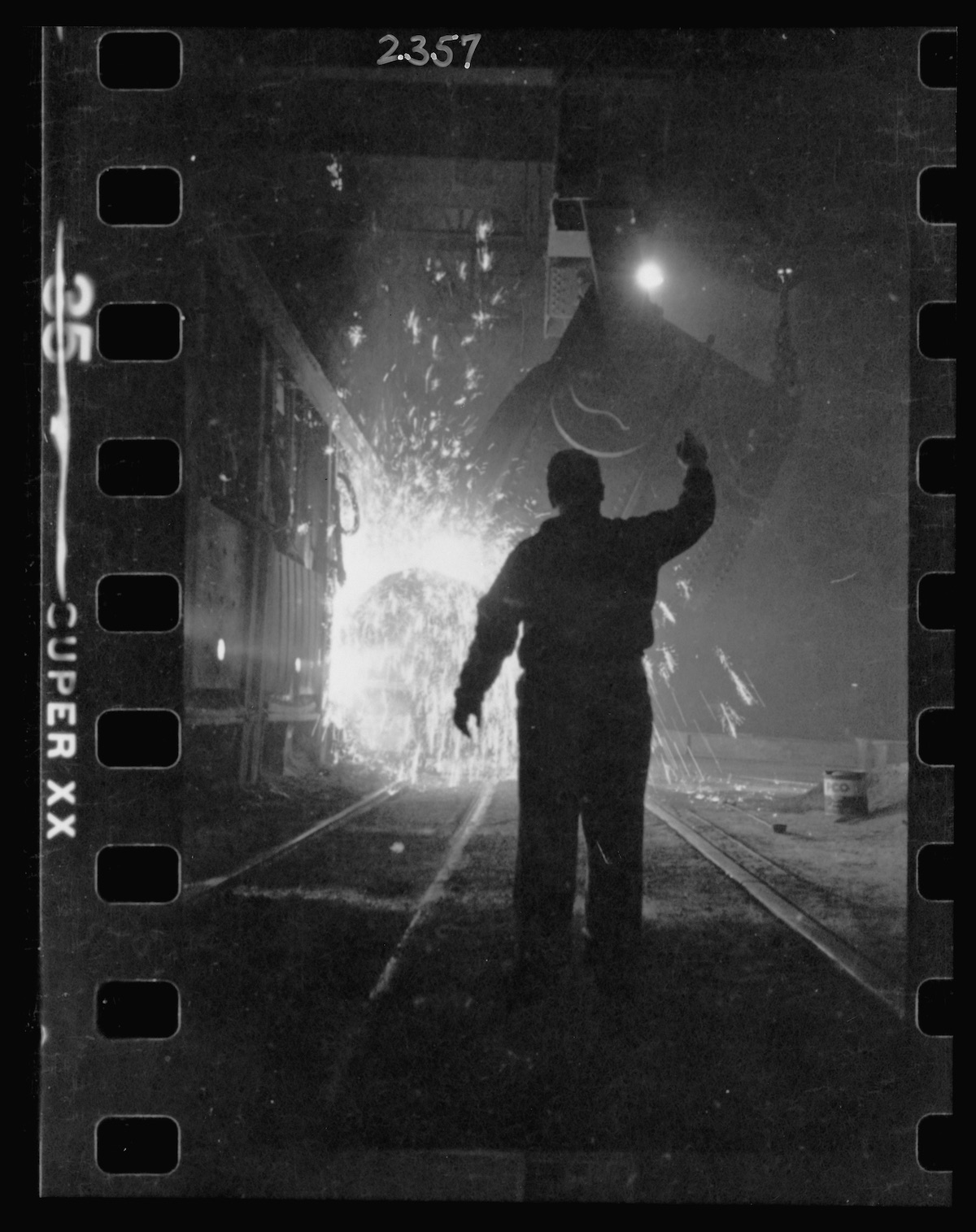 Steel worker in mill as molten steel spills from vat, in Chicago, Illinois
