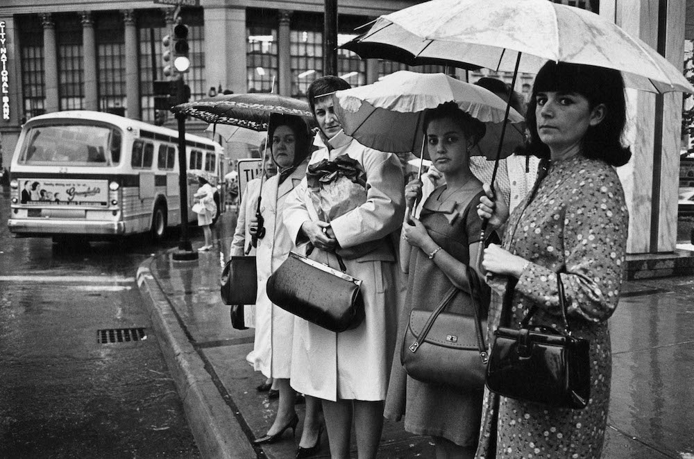 Enrico Natali (American, b. 1933) Women waiting at a bus stop in the rain, Detroit, 1968