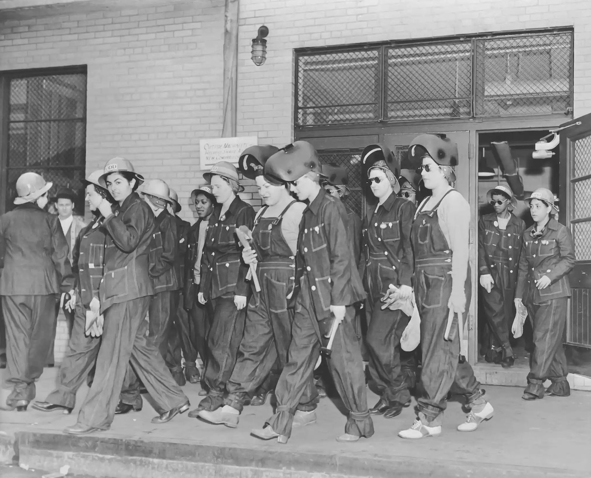 Women welders on the way to work democratically wearing denim overalls and jackets issued by the welding company