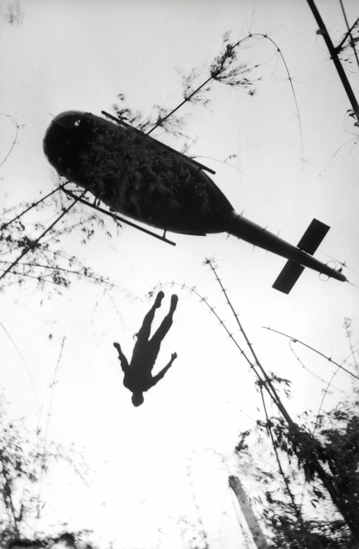 Henri Huet (French, 1927-1971) The body of an American paratrooper killed in action in the jungle near the Cambodian border is raised up to an evacuation helicopter, Vietnam 1966